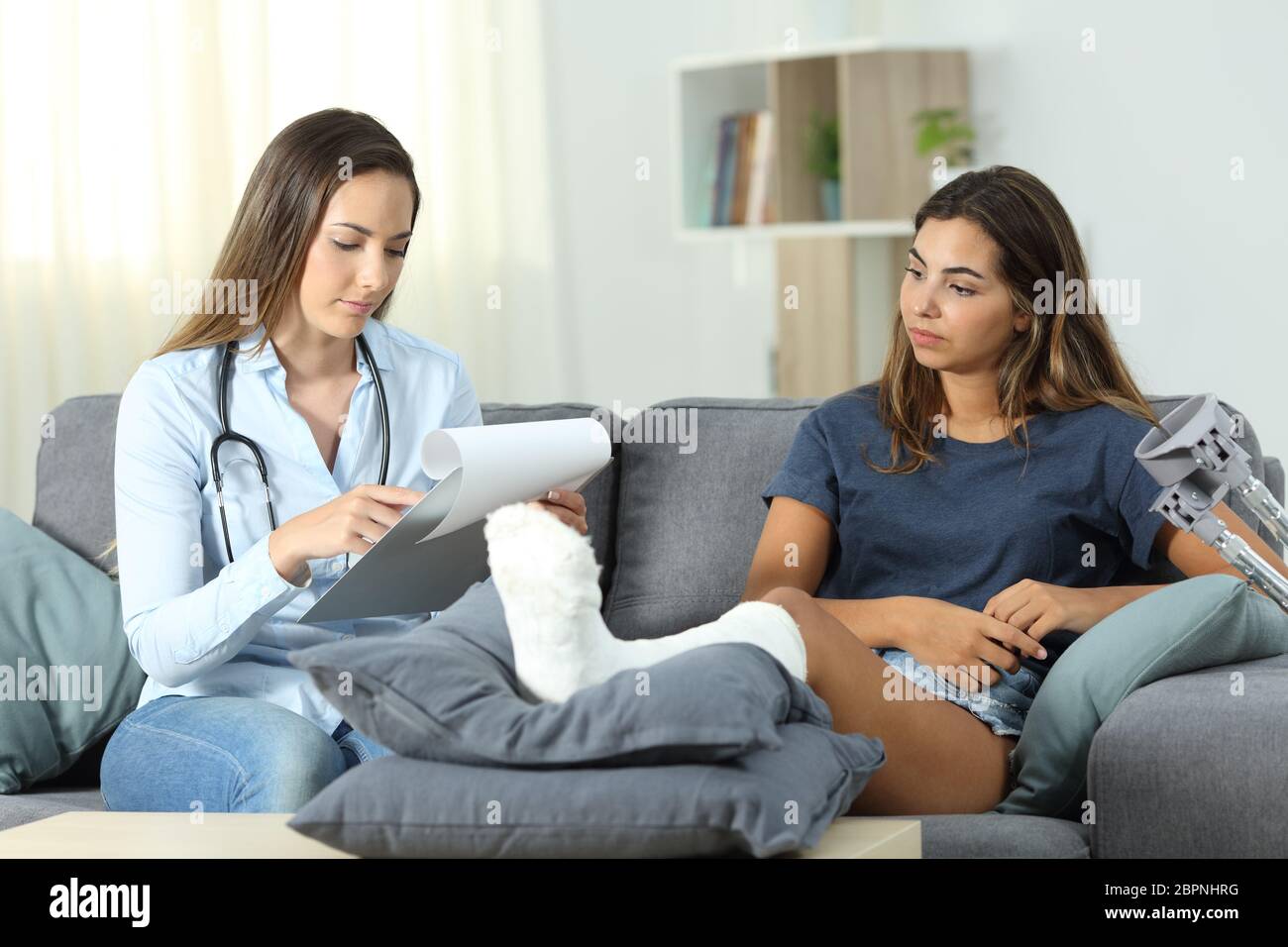 Doctor and patient checking medical history sitting on a couch in the