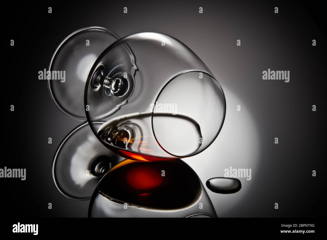 Snifter glass with cognac (brandy snifter, brandy bowl, cognac glass, or balloon) lying on a