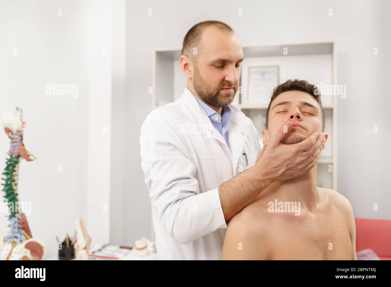 Manual therapist doing manual adjustment on patient's spine. Chiropractic, osteopathy, manual therapy, post traumatic rehabilitation, sport physical Stock Photo