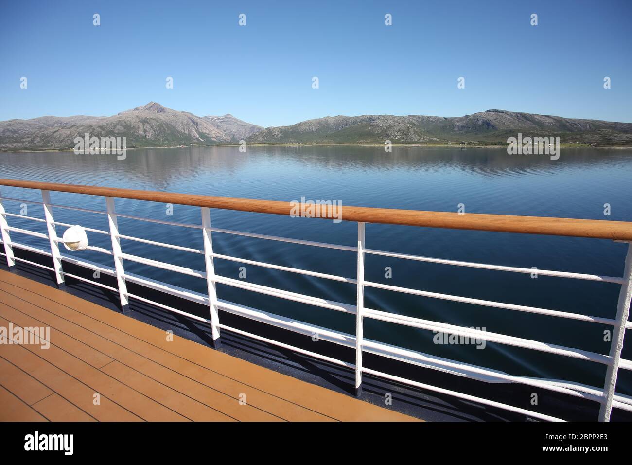 Deck & railing of a ship as it cruises fjords, islands & inside passages; the Andfjorden & Vestfjorden, between Bodo & Hammerfest, Norway. Stock Photo