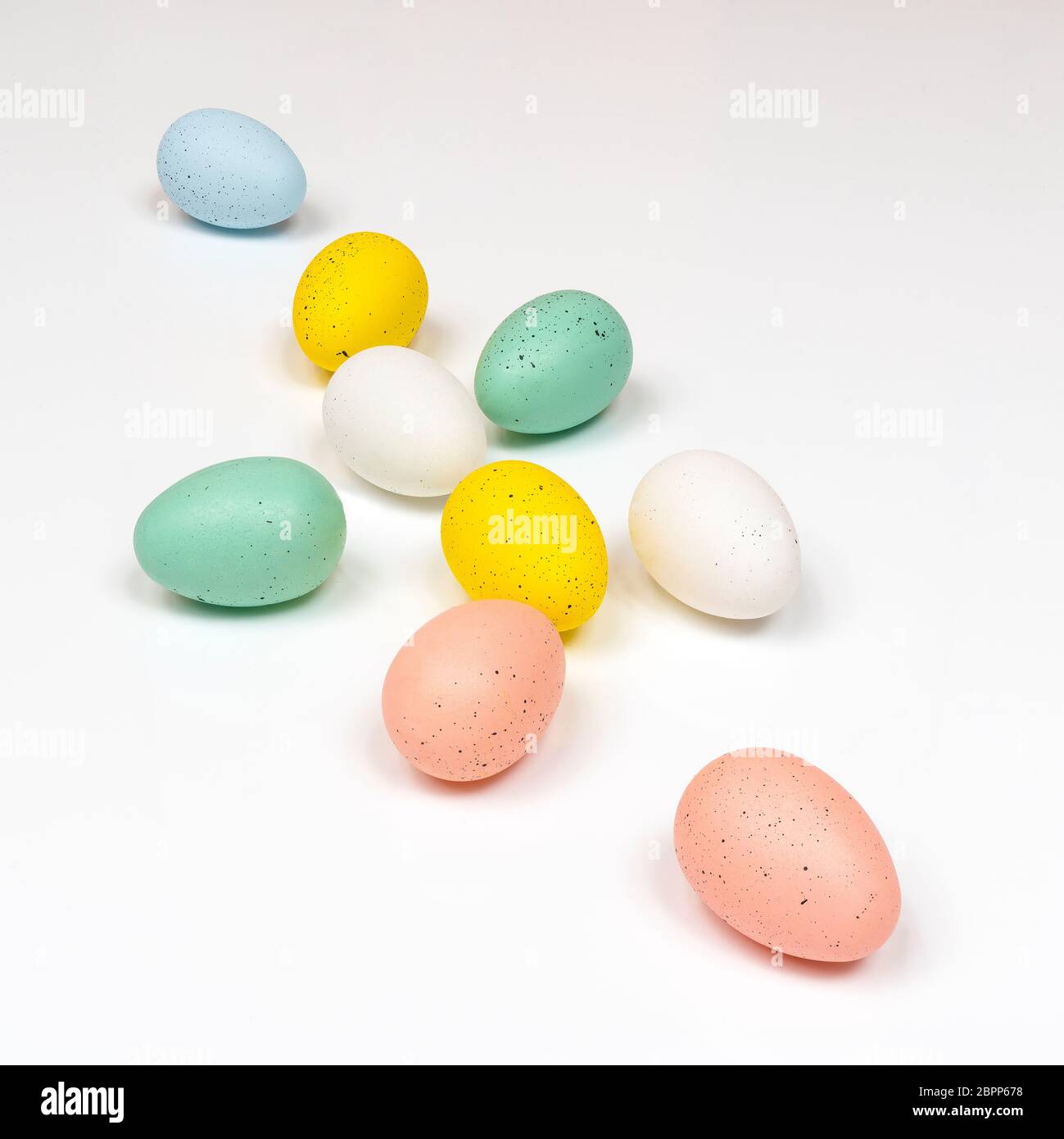colored easter eggs with little chicks on a white surface Stock Photo