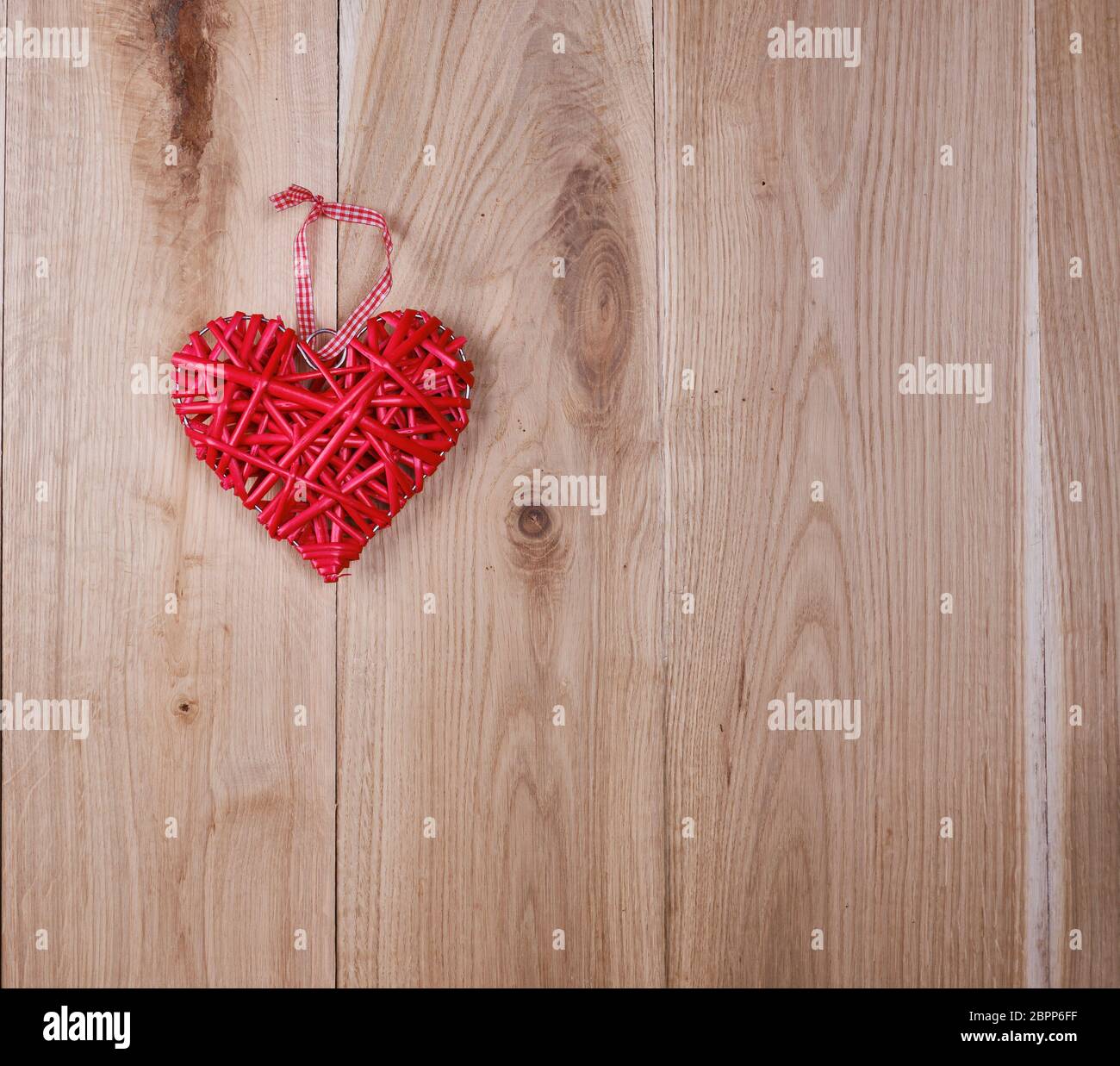 wooden background of oak boards and a red wicker heart, copy space Stock Photo