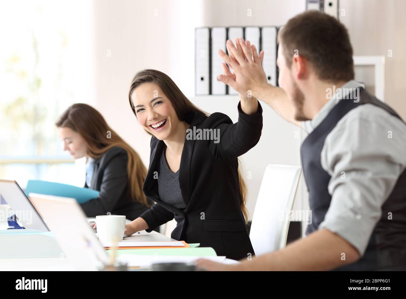 Two happy coworkers celebrating success giving five at office Stock ...