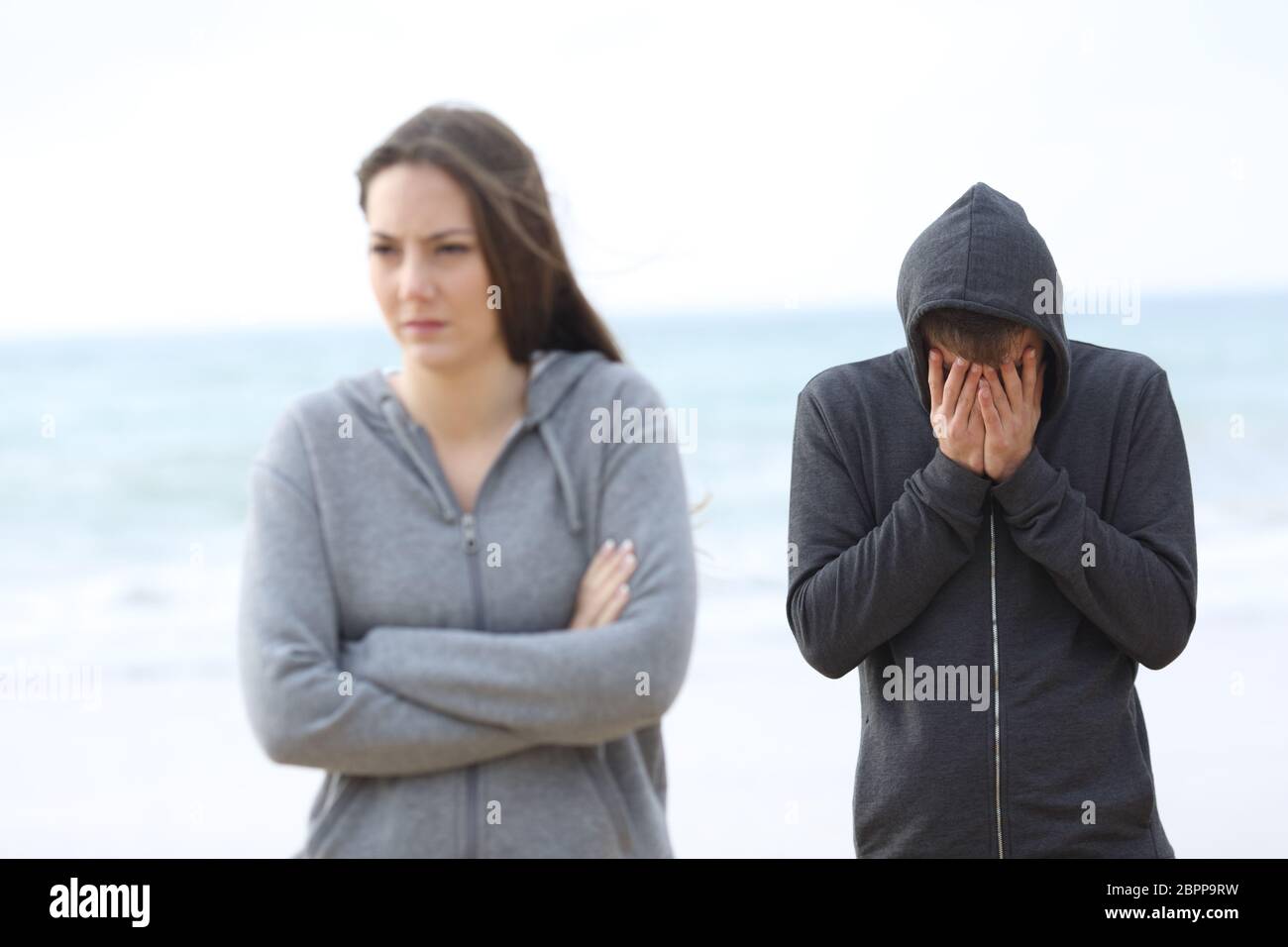 Couple break up on the beach with a girl leaving man alone Stock ...