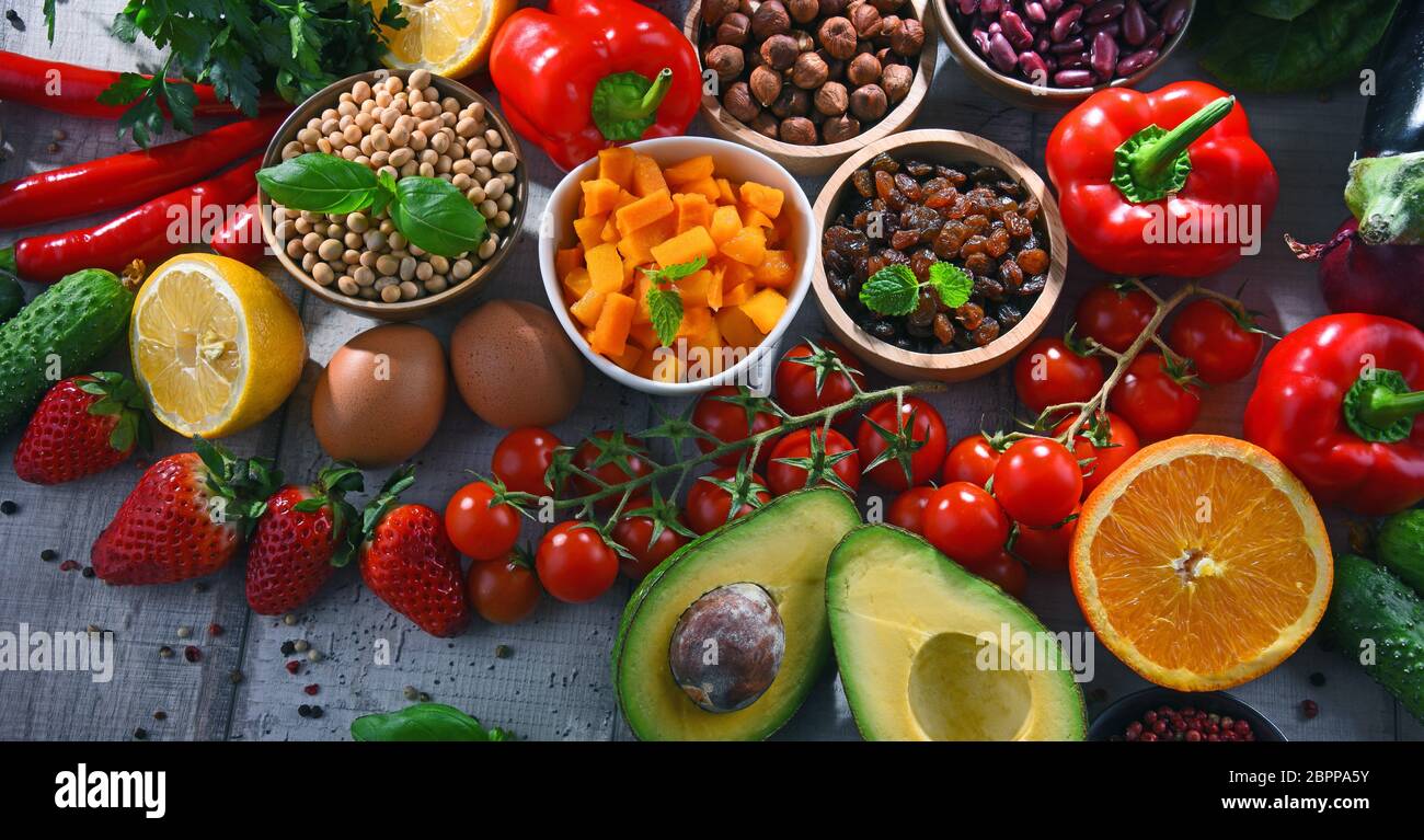 Composition with assorted organic food products on wooden kitchen table ...
