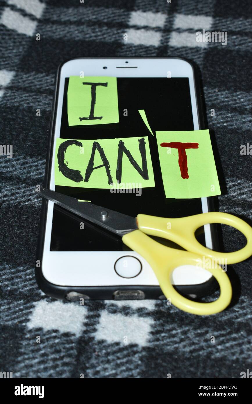 I can self motivation - cutting the letter 'T' of the written word I can't so it says I can, goal achievement, potential, overcoming.Mobile,Scissor in Stock Photo