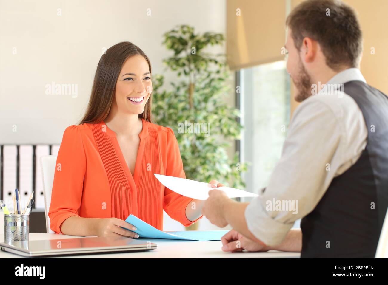 Woman giving a resume to the interviewer in a job interview Stock Photo