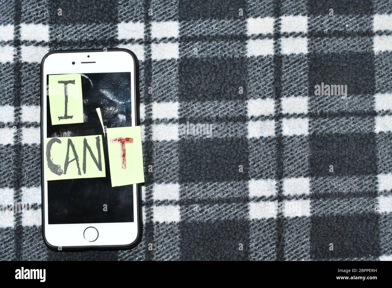 'I can' self motivation - cutting the letter 'T' of the written word I can't so it says I can, goal achievement, potential, overcoming.Mobile in the b Stock Photo
