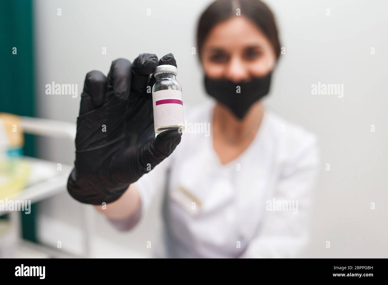 Cosmetologist holds ampoule with cosmetic substance in her hands