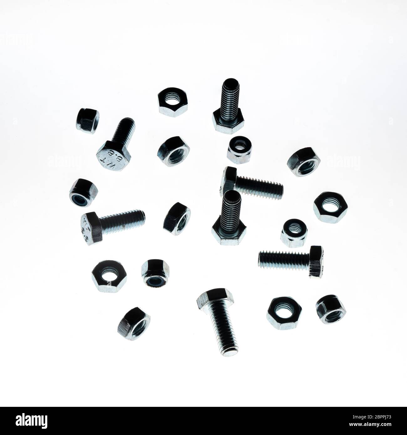 some lock nuts and bolts of various sizes on a white background Stock