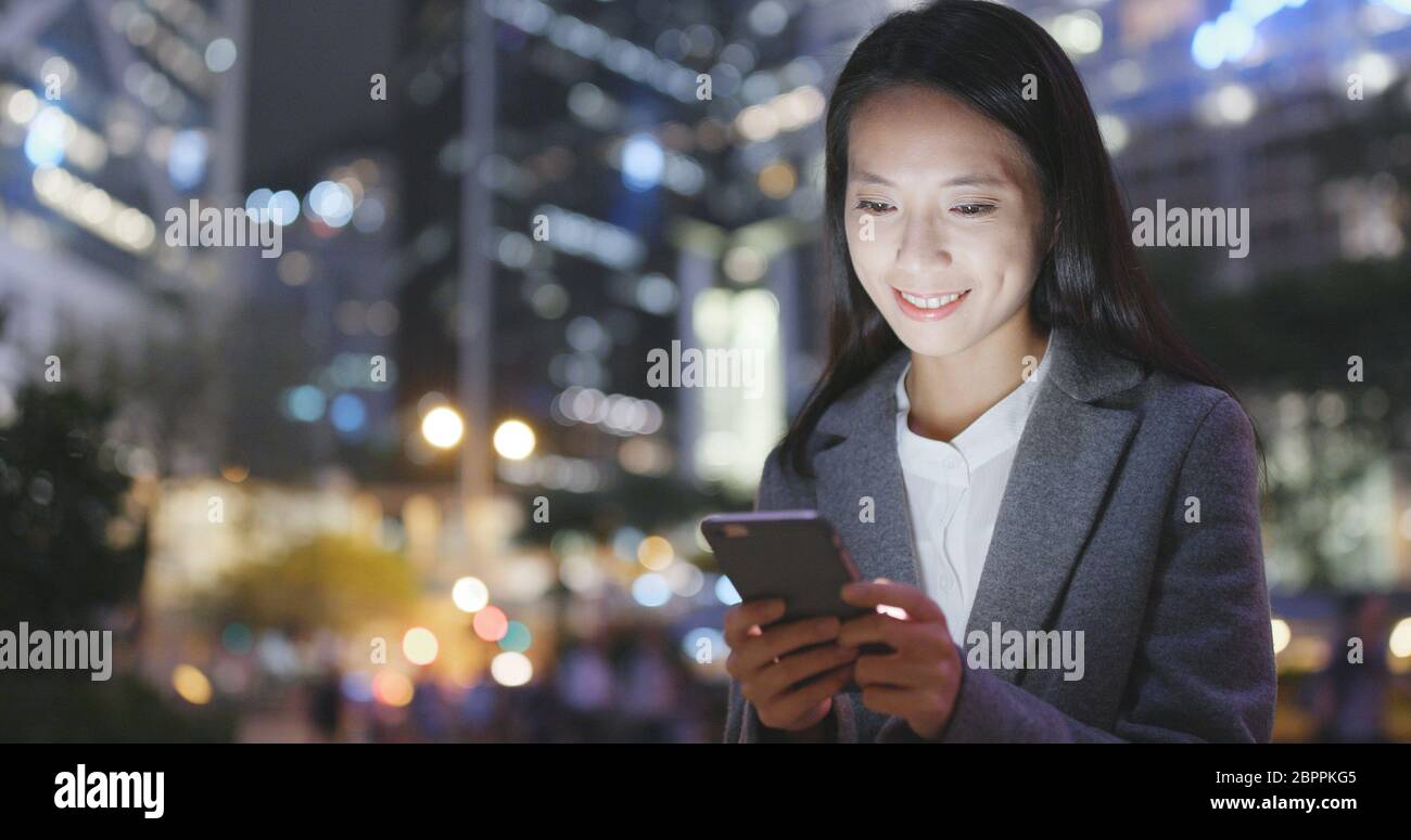 Business woman use of smart phone in Hong Kong at night Stock Photo - Alamy