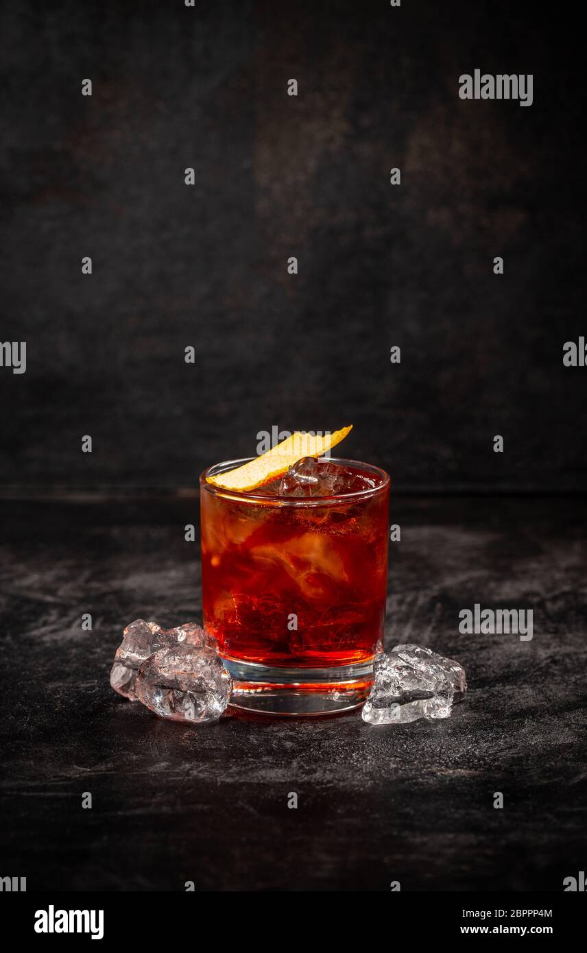 Negroni cocktail decorated with orange peel on dark background Stock Photo