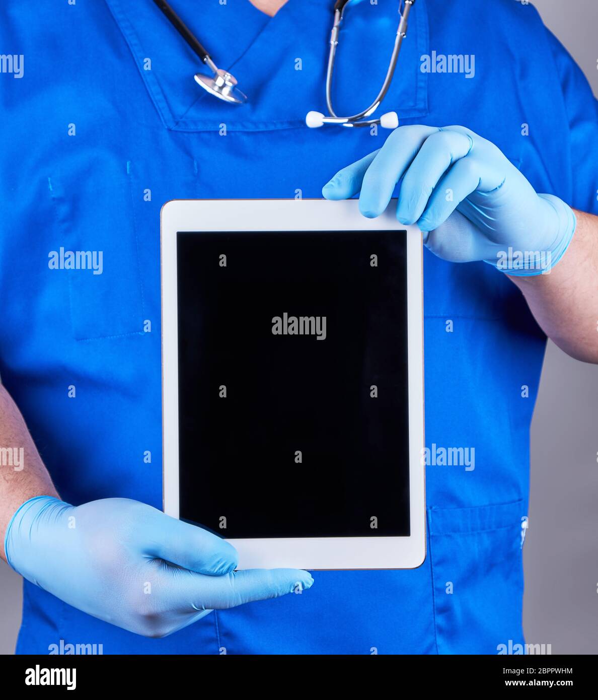 doctor in blue uniform and latex sterile gloves holding an electronic ...