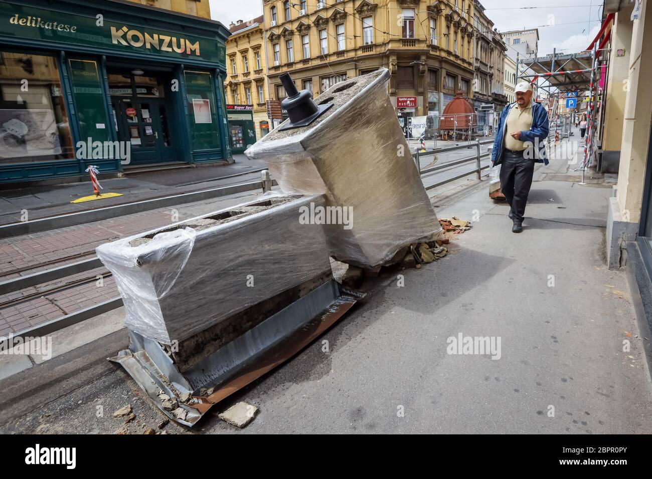 Zagreb, Croatia - April 16, 2020 : People pass by damaged chimneys that was damaged by the earthquake of 5.5 on the Richter scale one month ago and ar Stock Photo