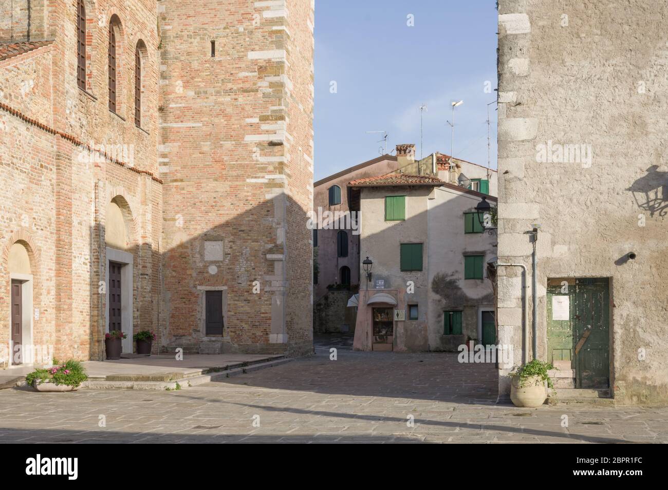Grado, Italy (17th May 2020) - The facade of the basilica of Saint Euphemia (VI a.C.) and the typical small square of Campo dei Patriarchi Stock Photo
