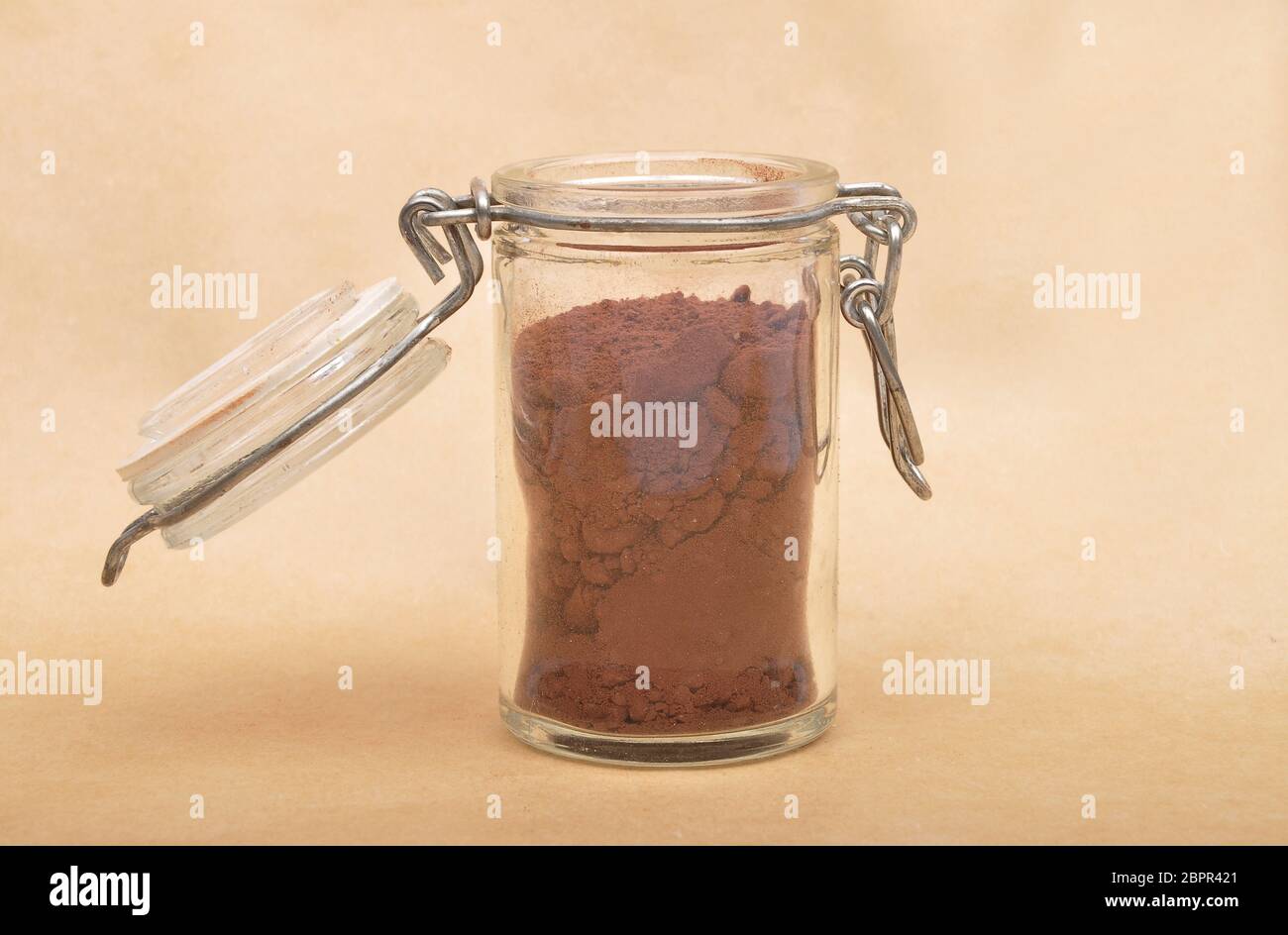 Cacao powder in  jar with lid on brown background Stock Photo