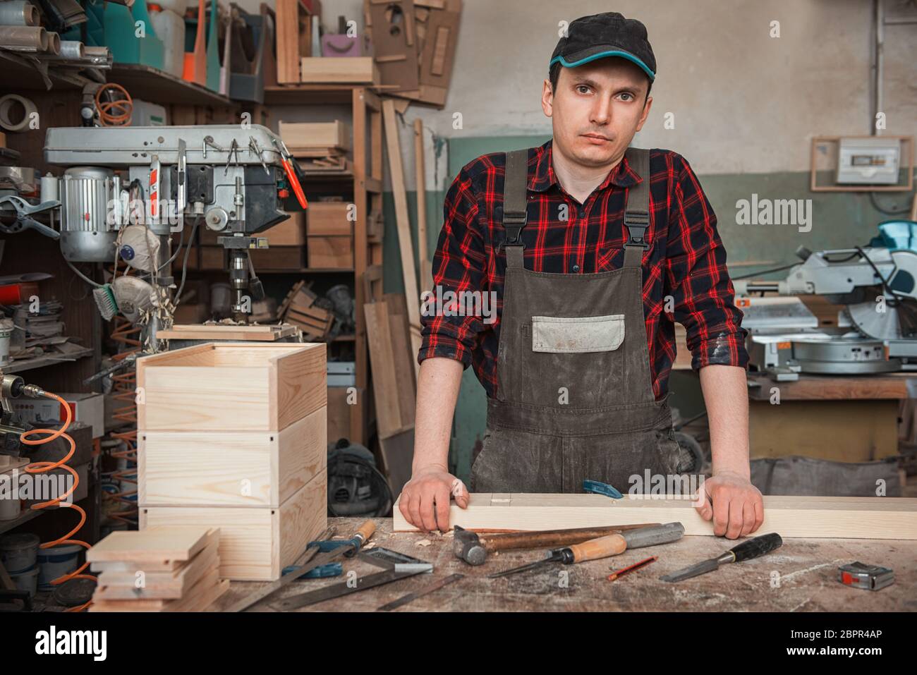 Carpenter working with a chisel and hammer in a wooden workshop Stock Photo