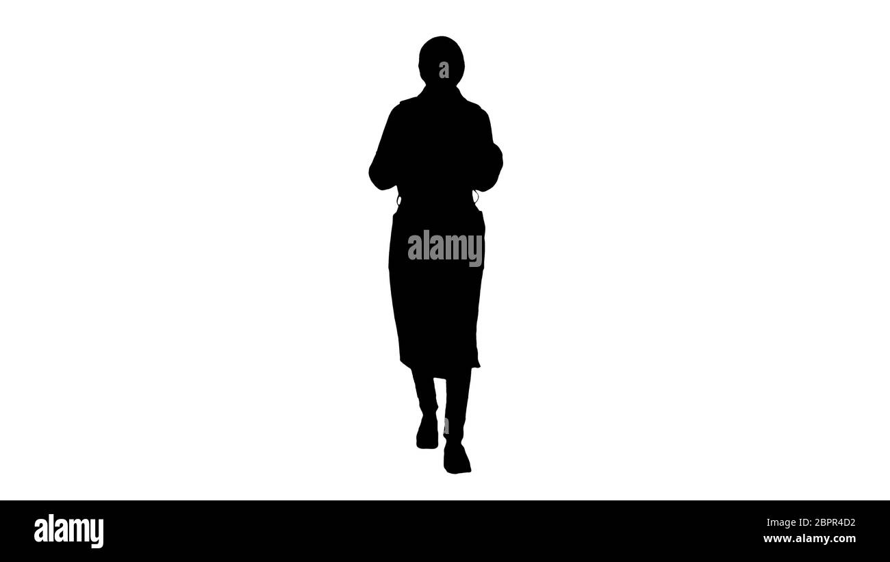 Silhouette Young woman wearing coat and backpack walking. Stock Photo