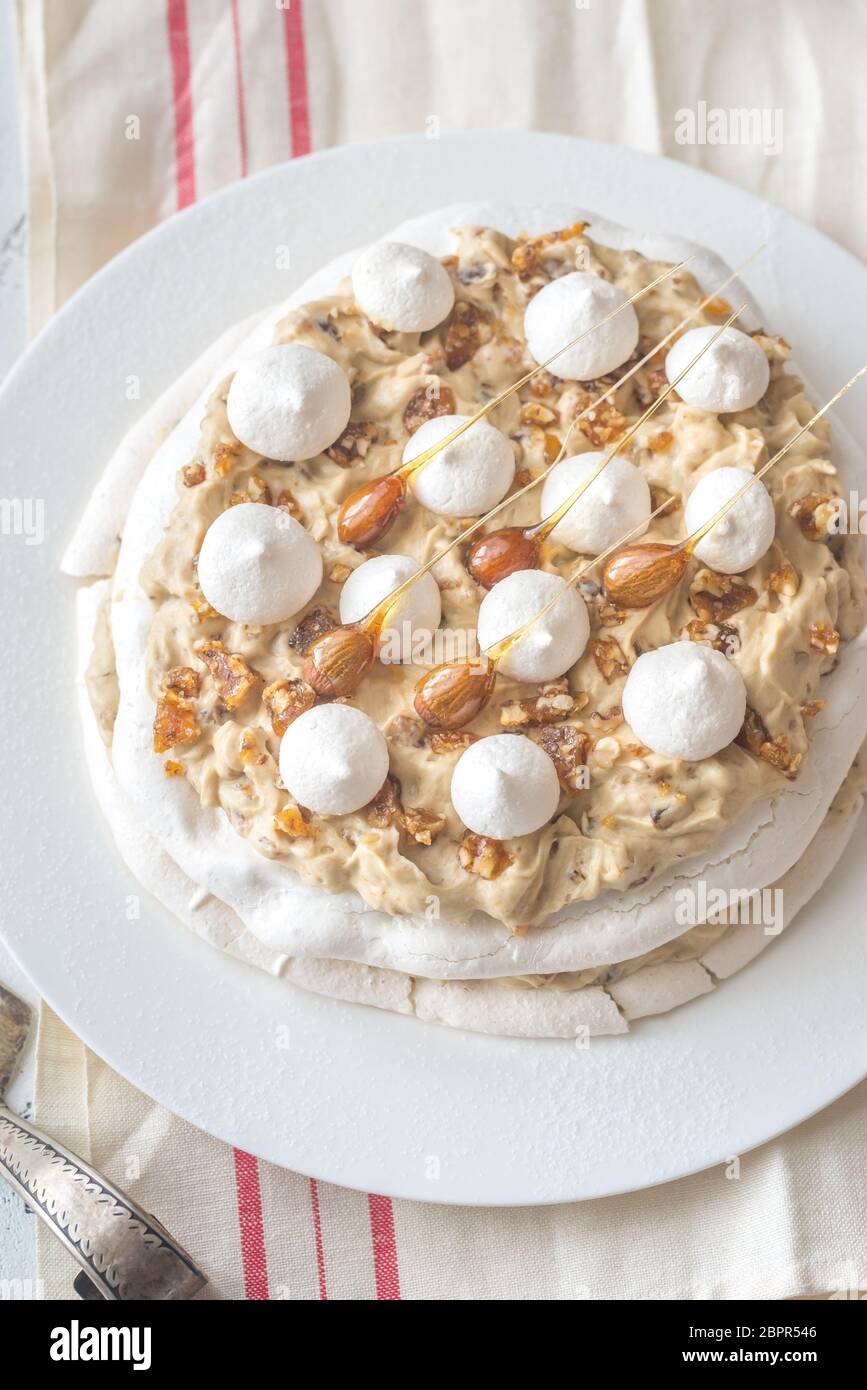 Pavlova cake with caramel and almonds on the wooden background Stock Photo