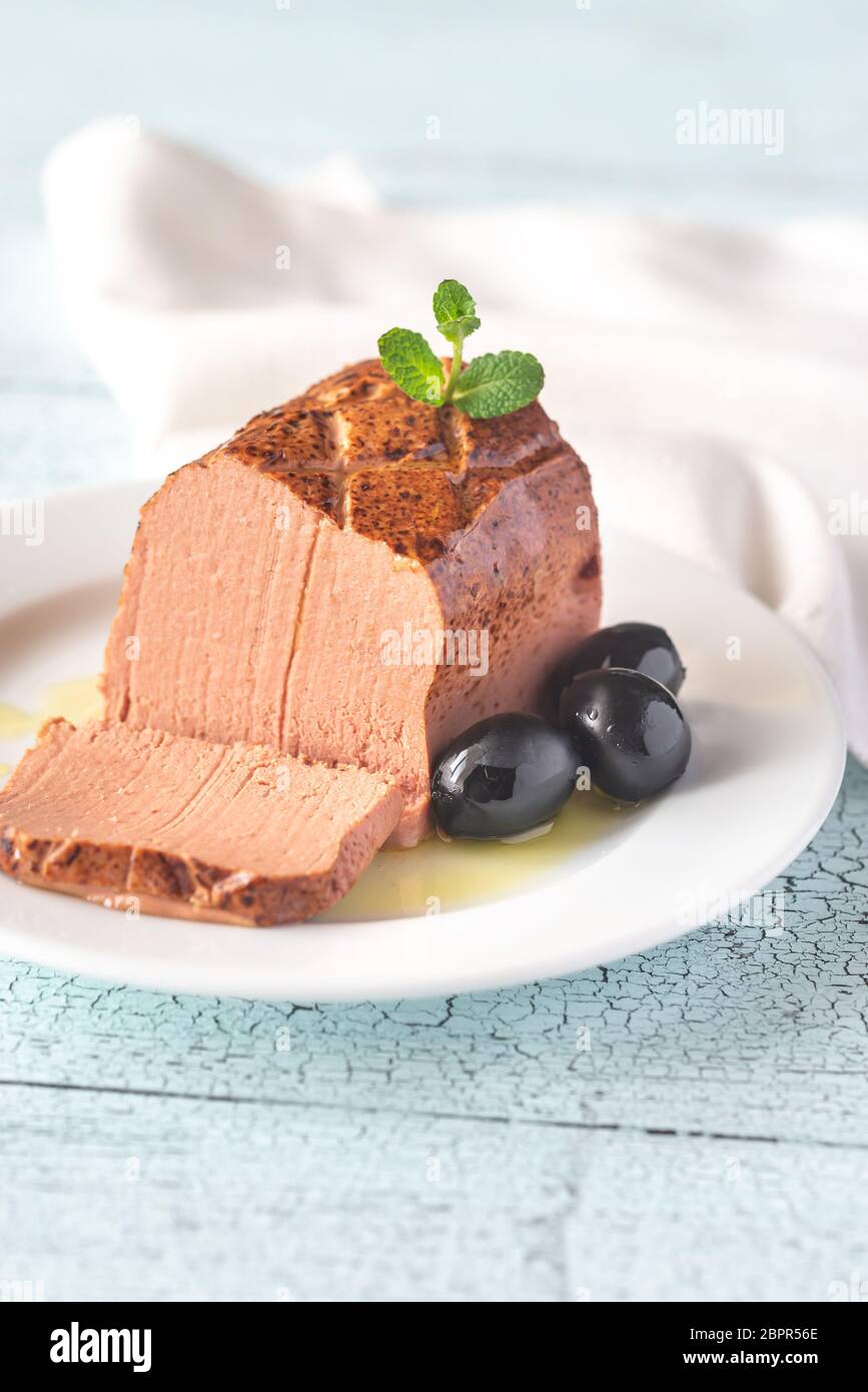 Chicken liver pate with black olives on the white plate cross section