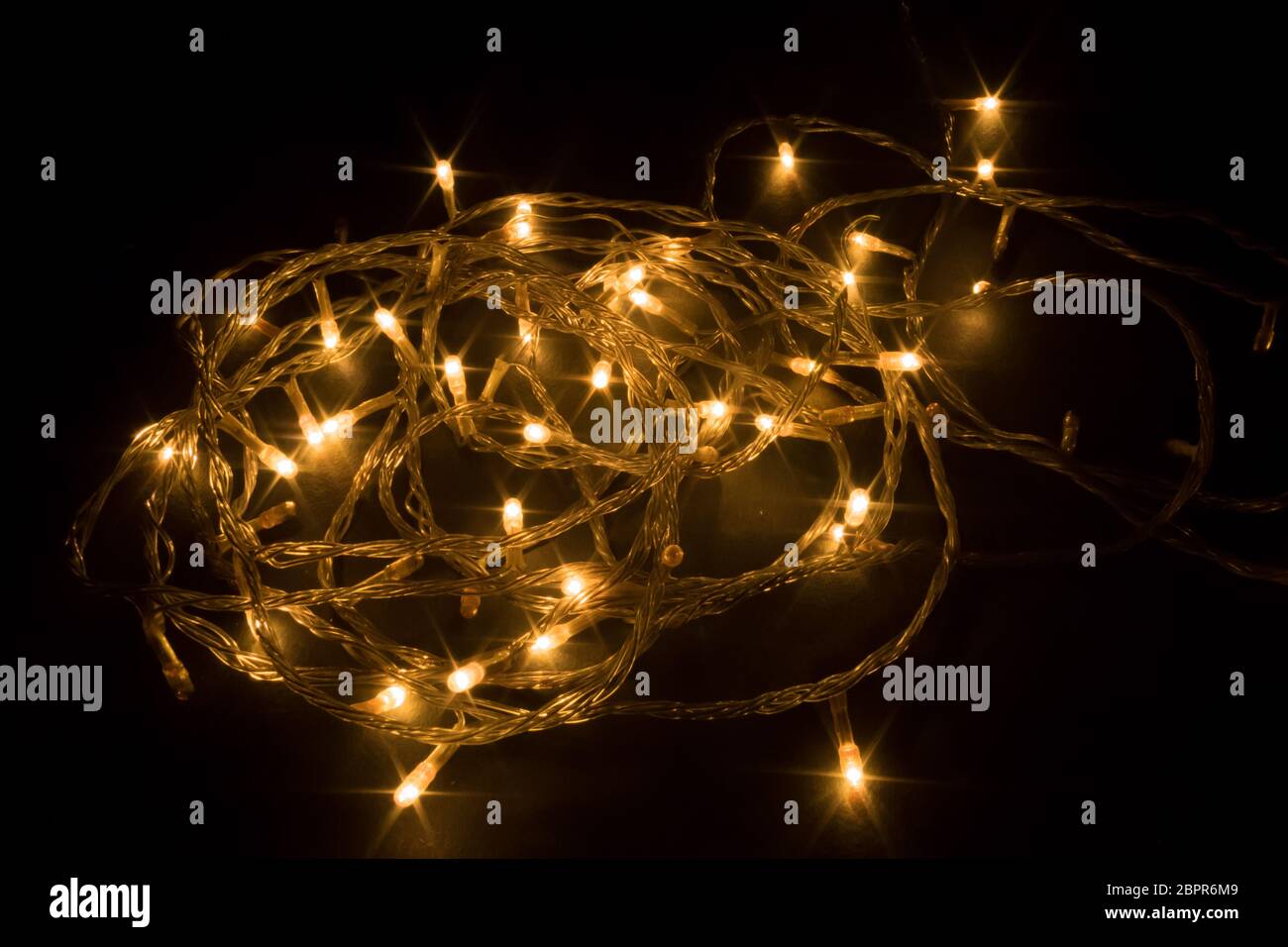 Diwali chain light, spiral shape, design to decorate street or home fireworks, dark black background shot in festival time or new years eve carnival, Stock Photo