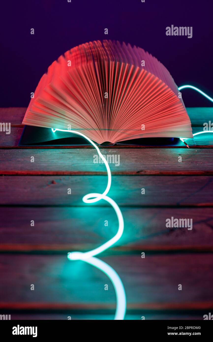 Open red book at a sea port at night with ice blue leading light