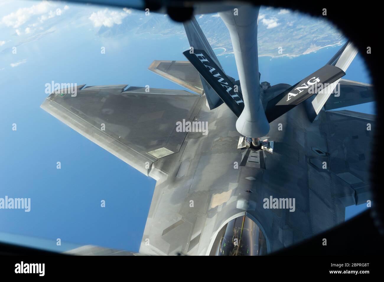 A KC-135 Stratotanker operated by Team Hickam refuels an F-22 Raptor during a routine training mission over the Hawaiian Islands, May 14, 2020. During the training mission aircrews from the Hawaii Air National Guard and 15th Wing conducted a flyover as part of Operation American Resolve throughout the Hawaiian Islands as a salute to all frontline workers battling COVID-19, as well as those staying home to 'flatten the curve of transmission' of the virus.  (U.S. Air National Guard photo by Tech. Sgt. Alison Bruce-Maldonado) Stock Photo