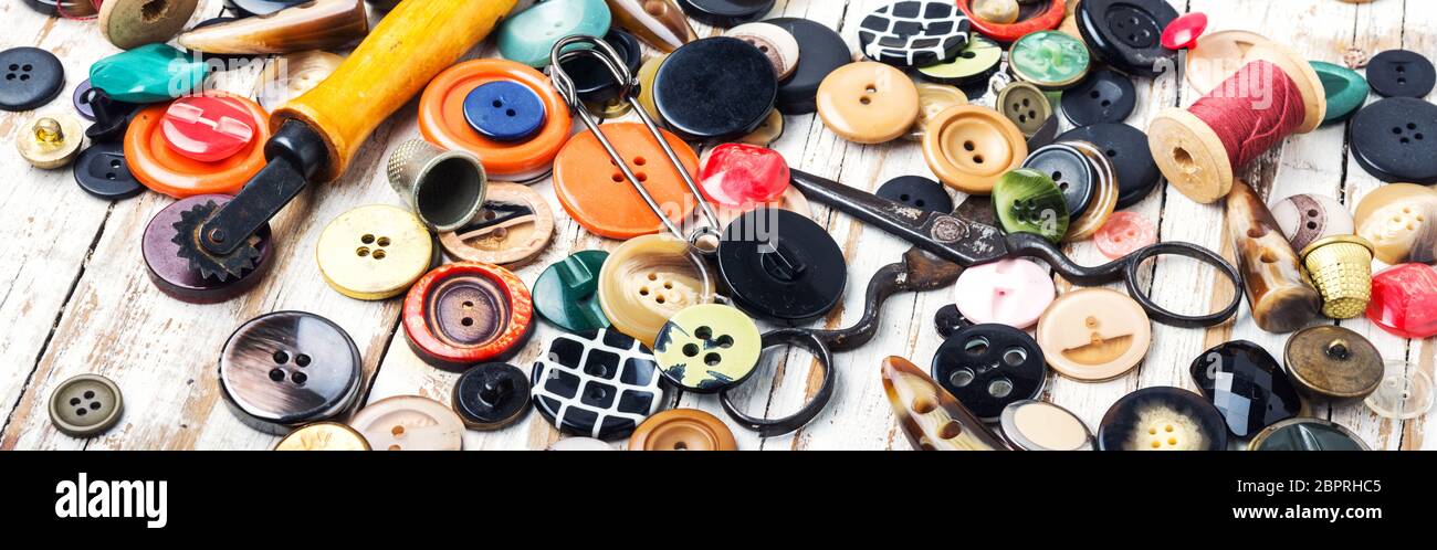 Spools of threads and buttons on wooden table.Scissor, sewing buttons ...