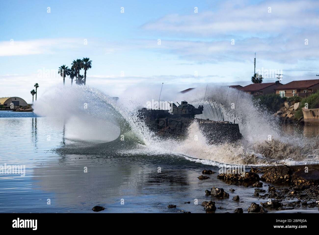 An AAV-P7/A1 Amphibious Assault Vehicle with Assault Amphibian School splashes into the Del Mar Boat Basin on Marine Corps Base Camp Pendleton, California, May 18, 2020. The students are currently participating in the 55 day-long assault amphibian crewman course, where they are taught to maintain an AAV and associated equipment, how to operate an AAV on land and water along with introductory troubleshooting and self-recovery maneuvers. (U.S. Marine Corps photo by Lance Cpl. Drake Nickels) Stock Photo