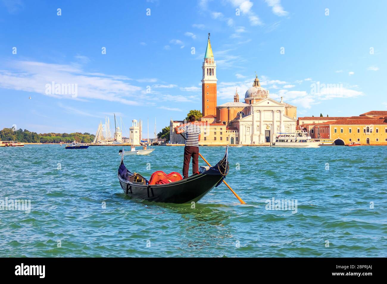 Gondolier in a gondola near San Giorgio Maggiore in Venice, Italy. Stock Photo