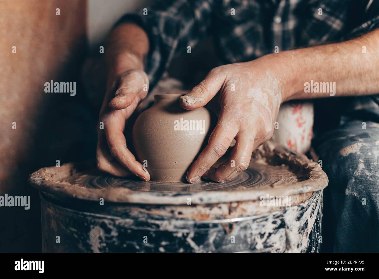 The potter is holding a newly made jug from white clay Stock Photo