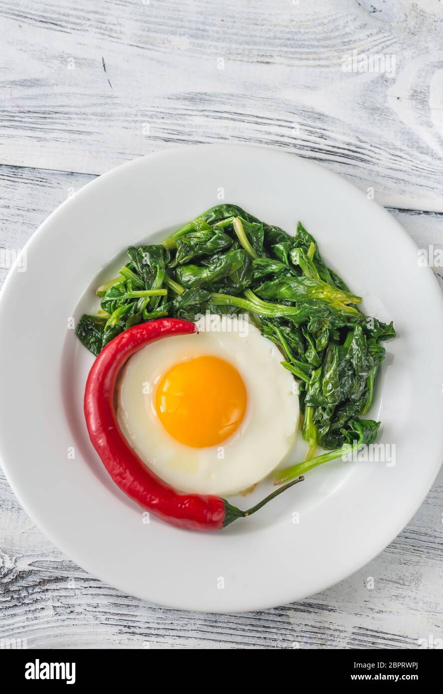 Fried egg with spinach and fresh chilli Stock Photo Alamy