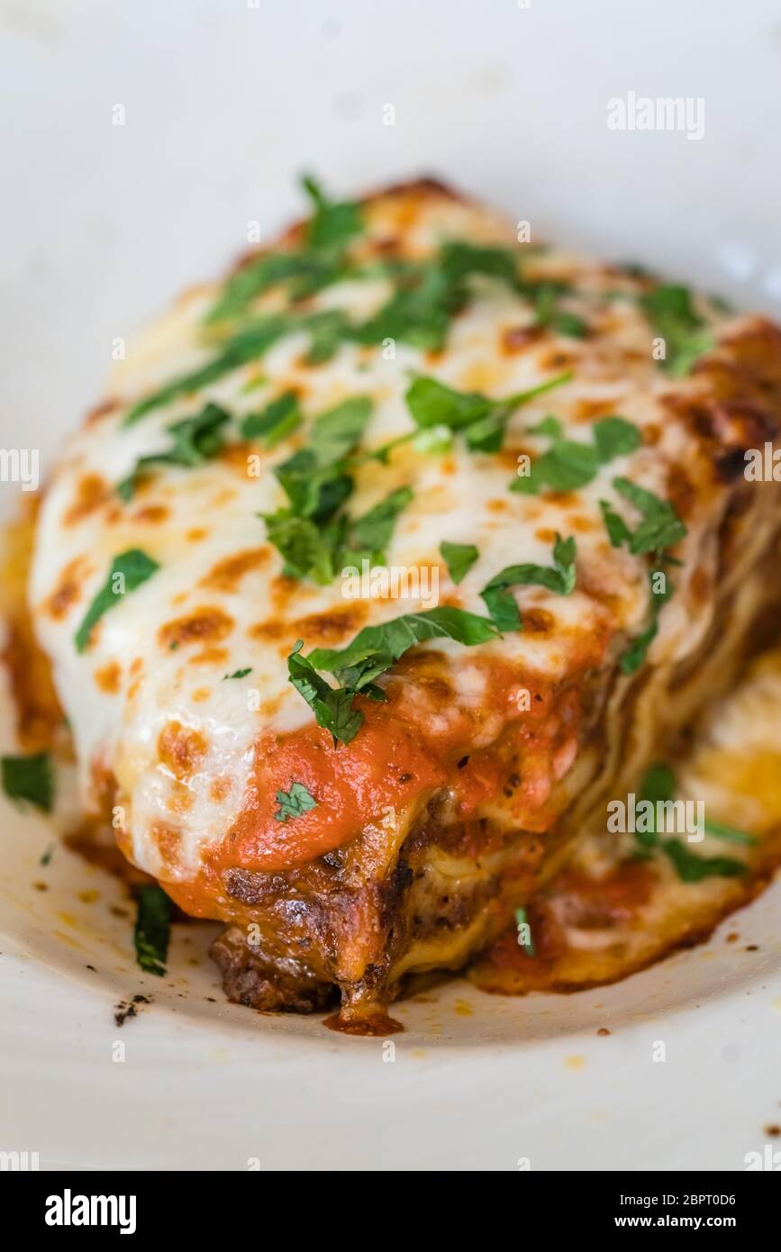 Portion of a delicious beef lasagne with melting cheddar, mozzarella