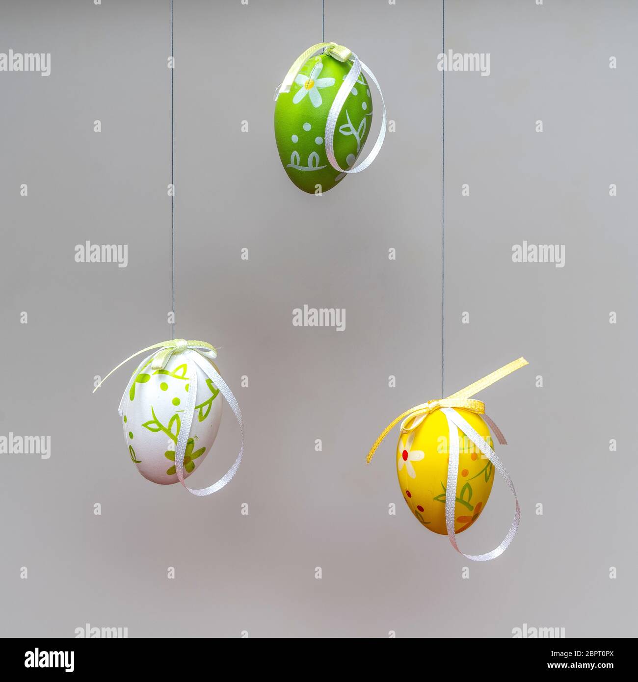 some colorful and decorated Easter eggs hanging by a thread Stock Photo