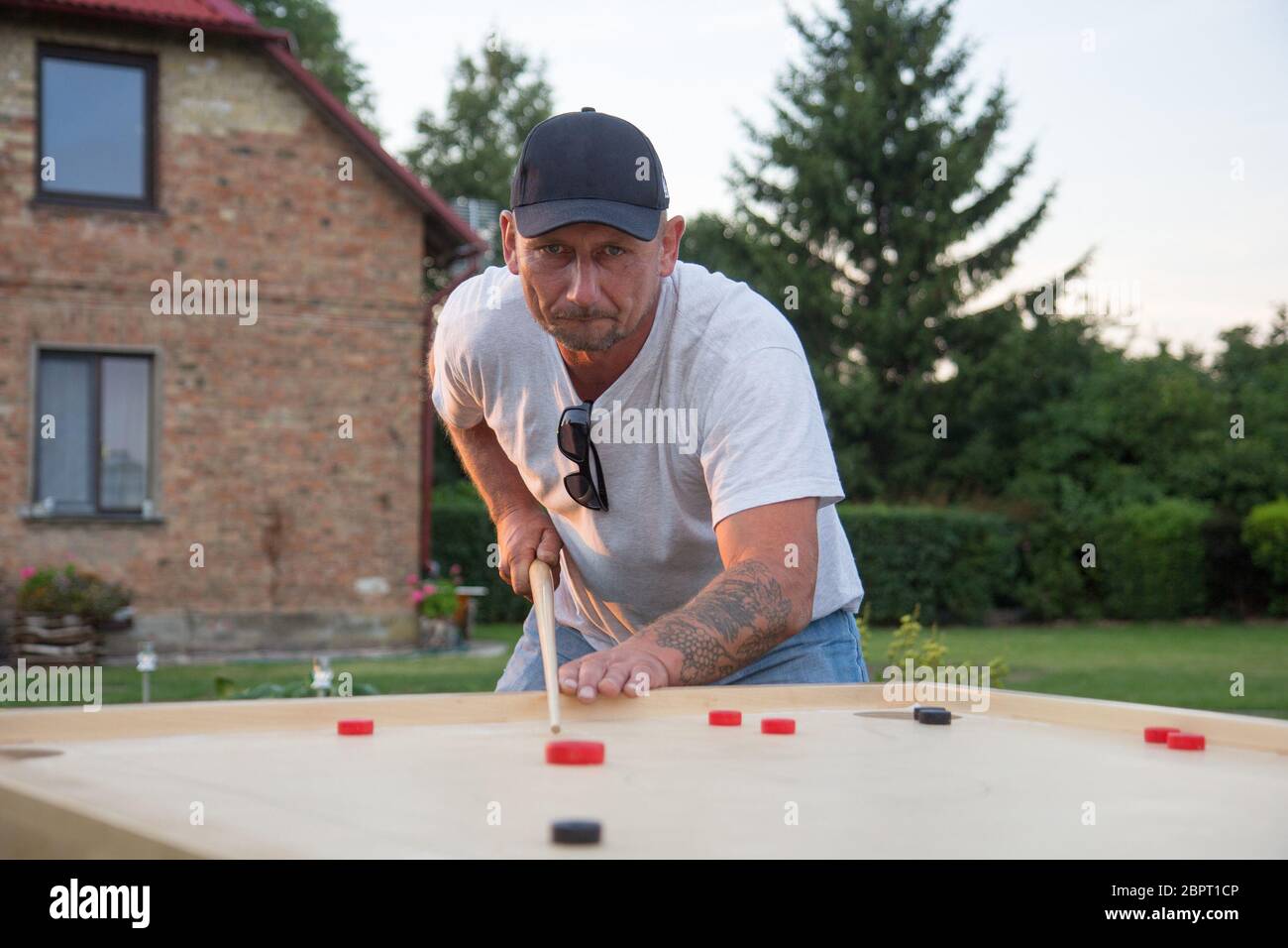 Man playing Novuss in outdoors. Novuss is a national sport in Latvia similar to pocket billiards or pool. Stock Photo