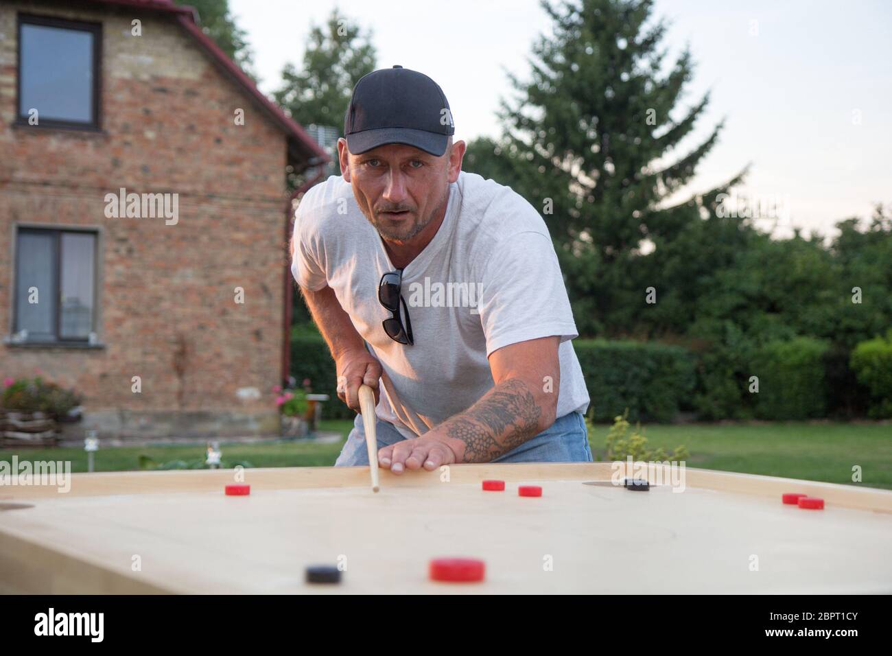 Man playing Novuss in outdoors. Novuss is a national sport in Latvia similar to pocket billiards or pool. Stock Photo