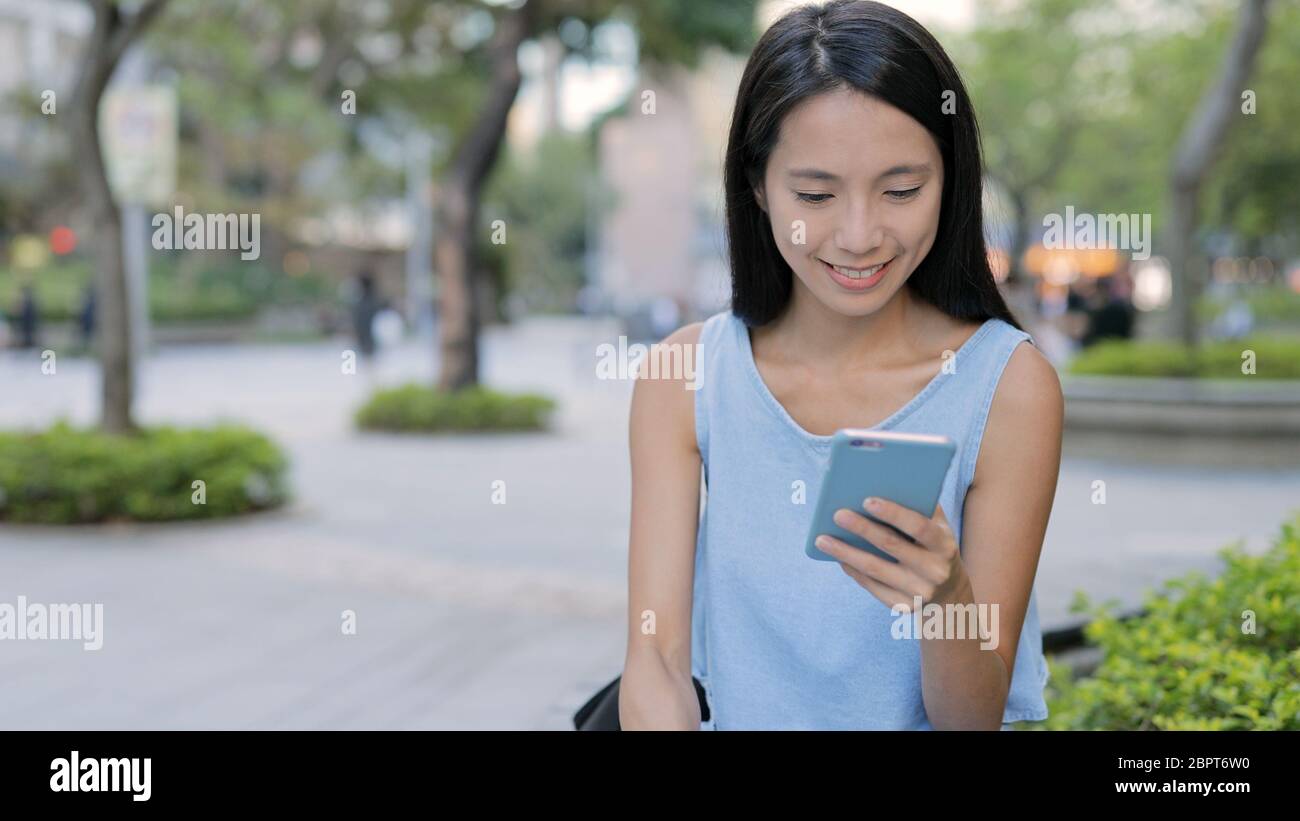 Asian woman use of mobile phone in the city Stock Photo - Alamy