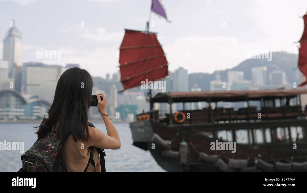 Woman taking photo on cellphone in Hong Kong city Stock Photo - Alamy