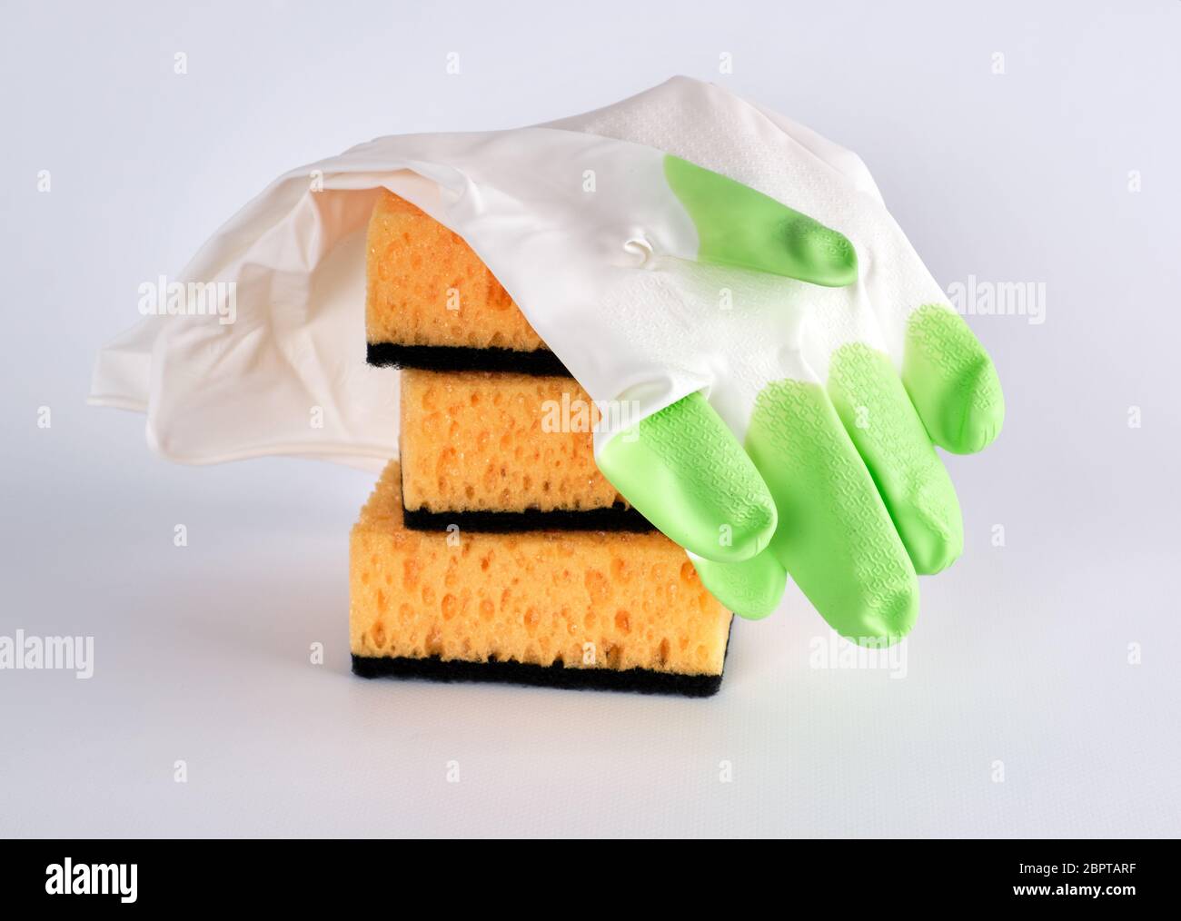 https://c8.alamy.com/comp/2BPTARF/stack-of-yellow-kitchen-sponges-for-washing-dishes-and-gloves-on-a-white-background-2BPTARF.jpg