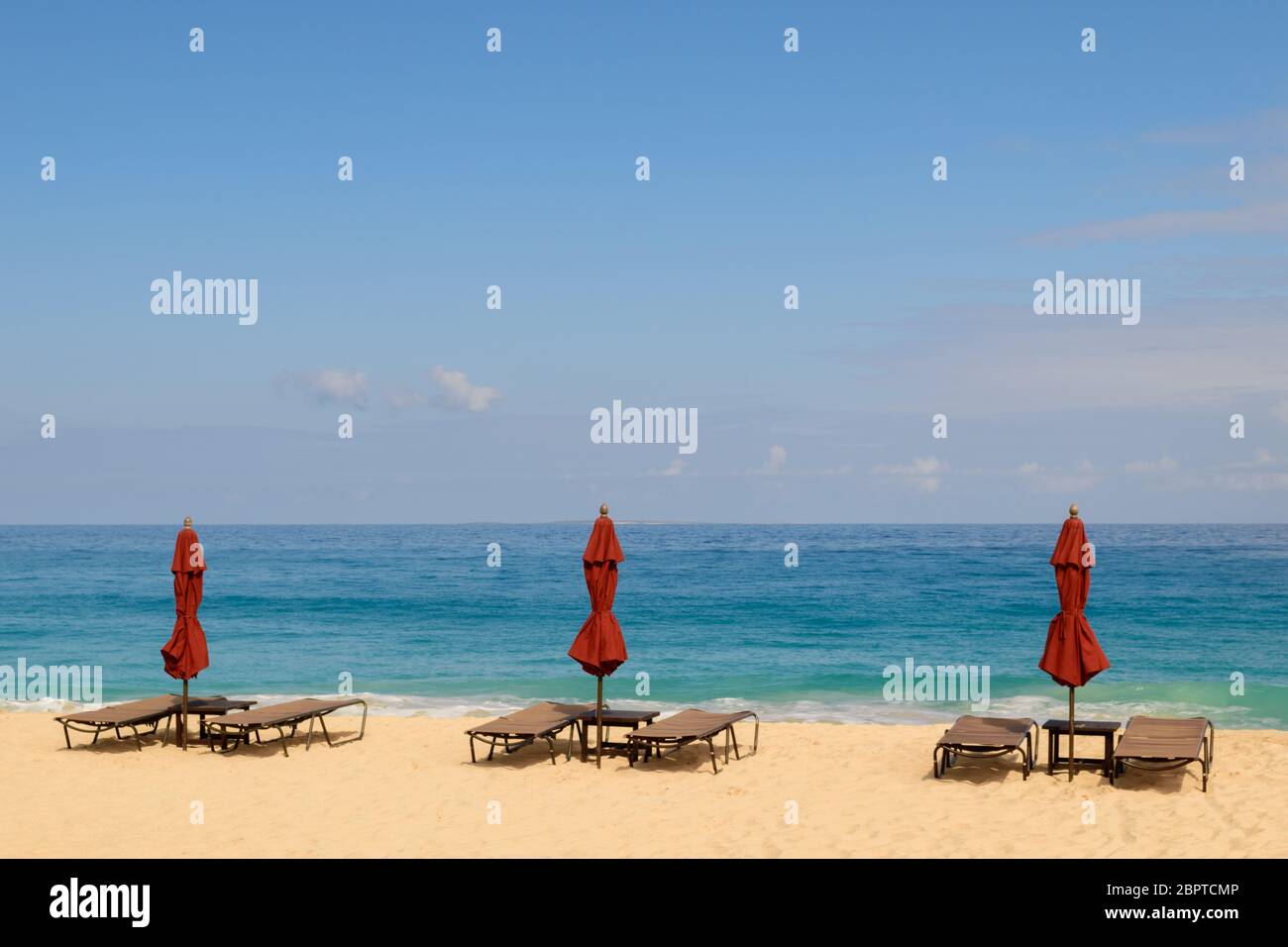 Red beach umbrellas on a beautiful day in Anguilla Stock Photo