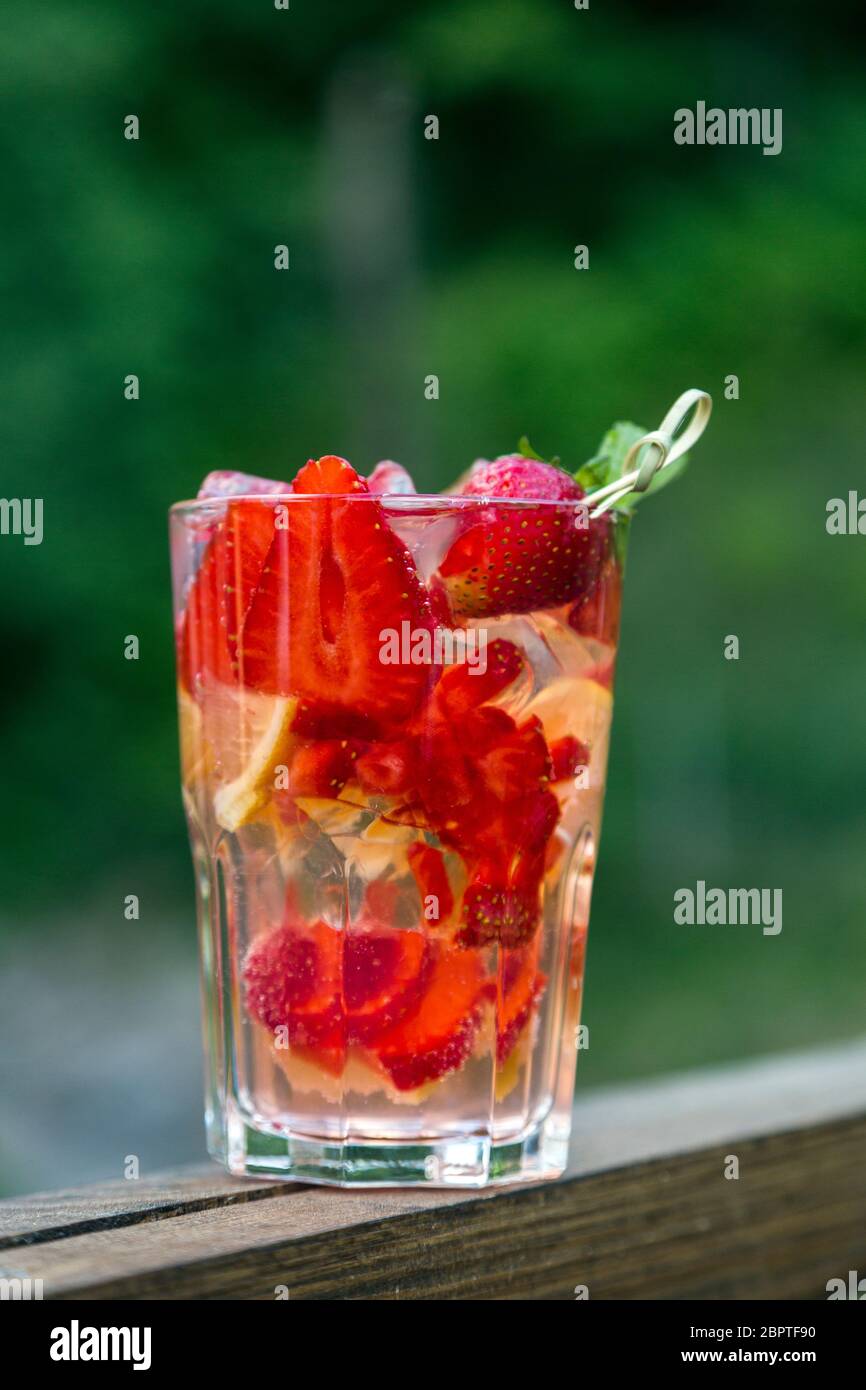 A fresh summer non alcoholic fruit and berry cocktail. Juicy strawberry with apple and mint with ice Stock Photo