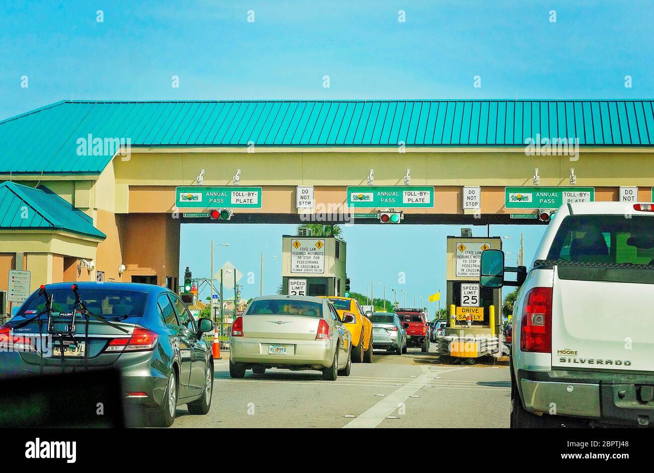 Traffic enters the Pensacola Beach Bridge toll booth, May 16, 2020, in Gulf Breeze, Florida. The beach recently reopened after closing for COVID-19. Stock Photo