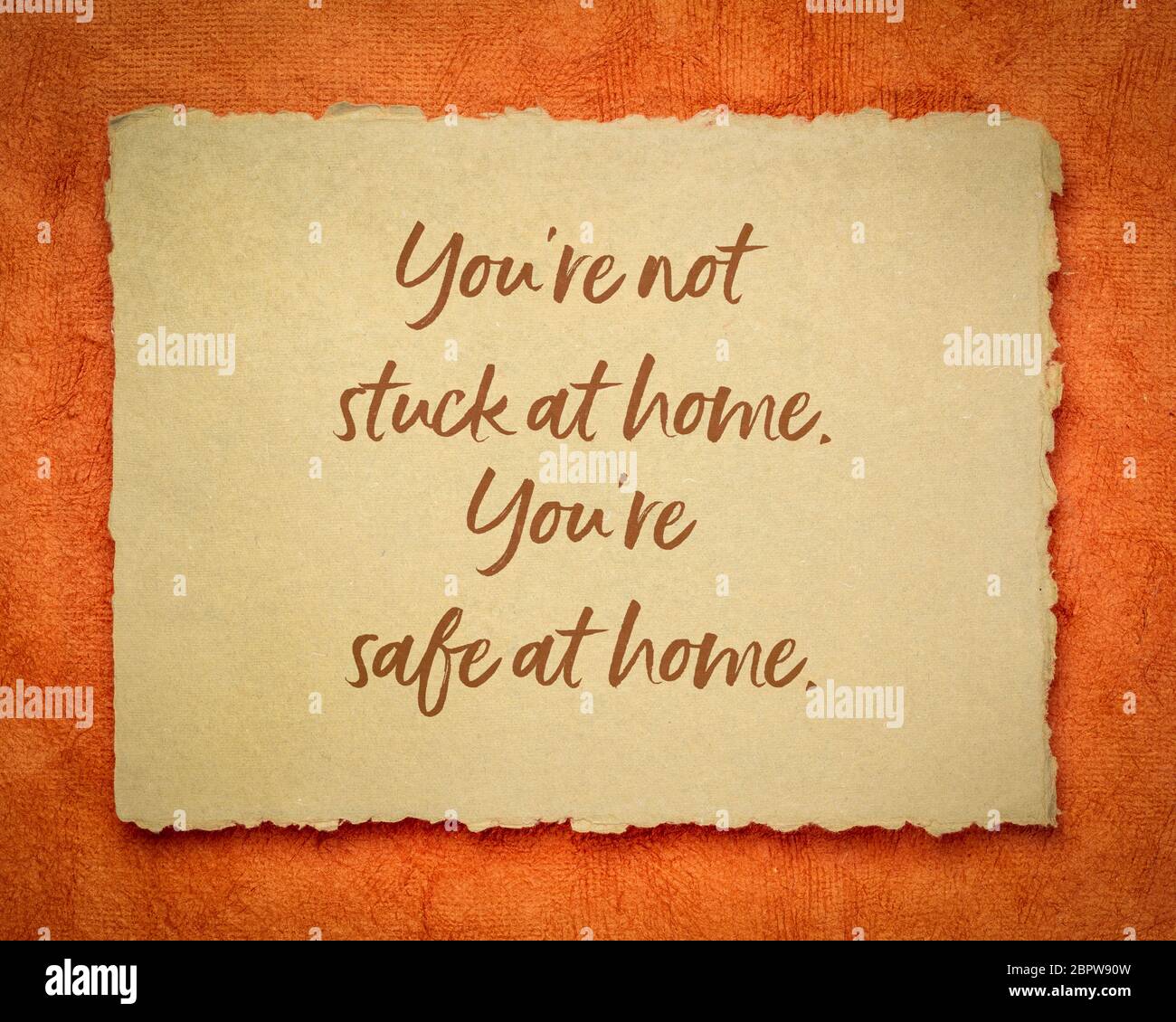 you are not stuck at home, you are safe at home - inspirational note on a handmade rag paper, reminder for self isolation or quarantine during coronav Stock Photo