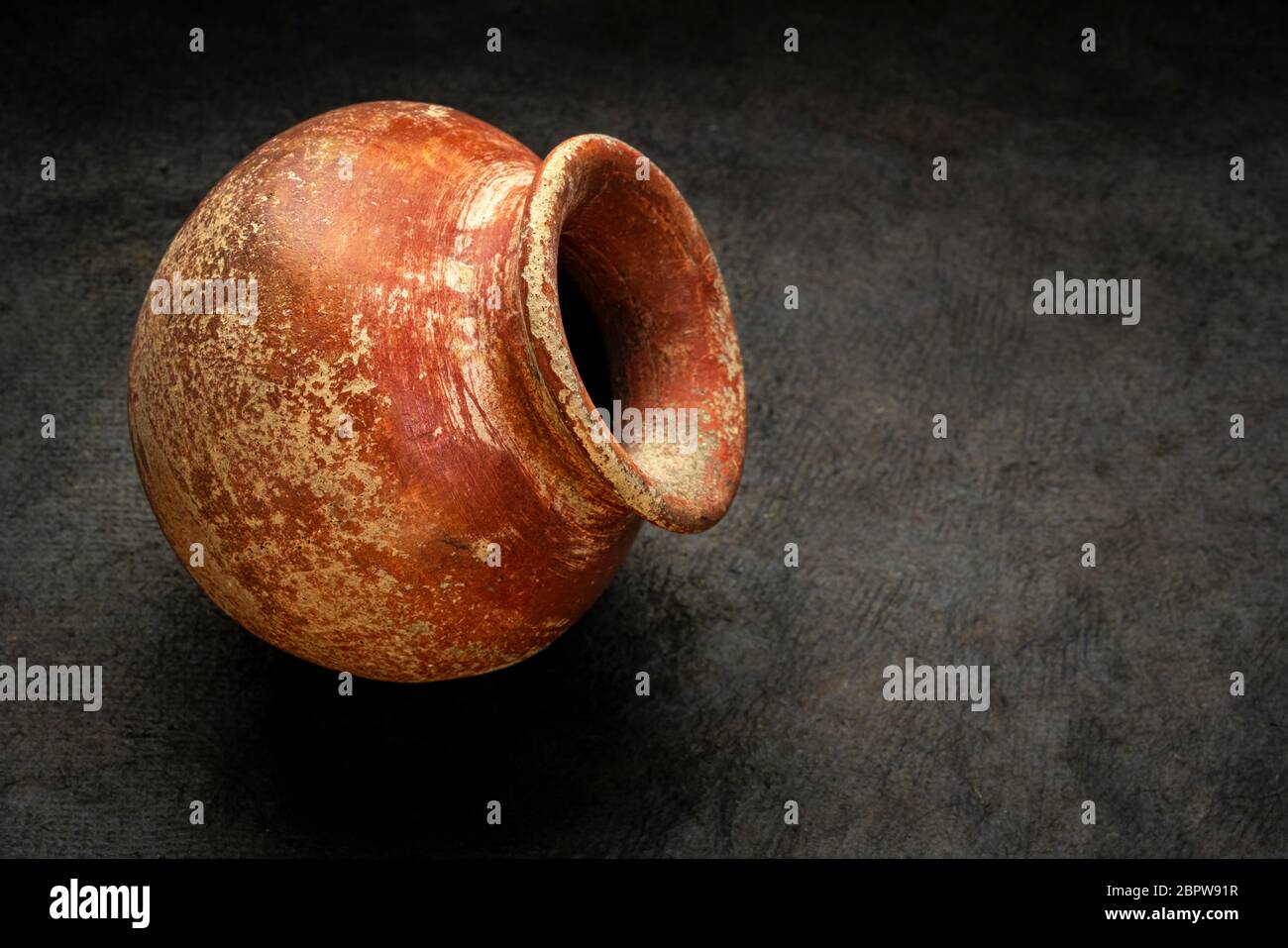 small red and brown clay plant pot (mass produced planter) with rough