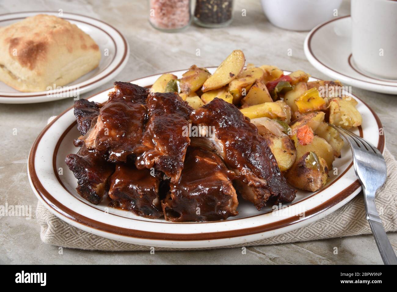 Gourmet barbecue beef ribs with roasted potato wedges with green and