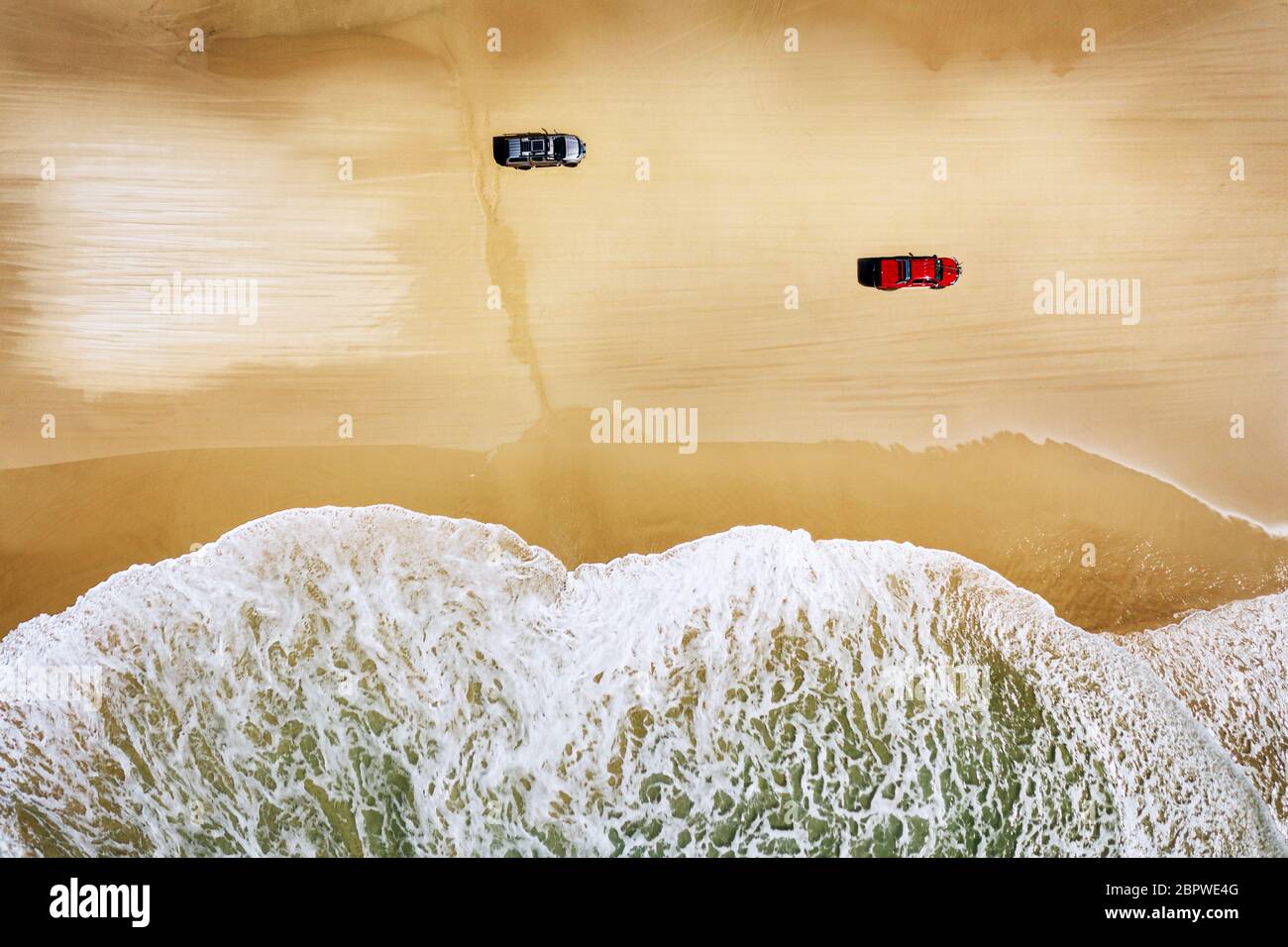 Two cars driving along Seventy Five Mile Beach on famous Fraser Island. Stock Photo
