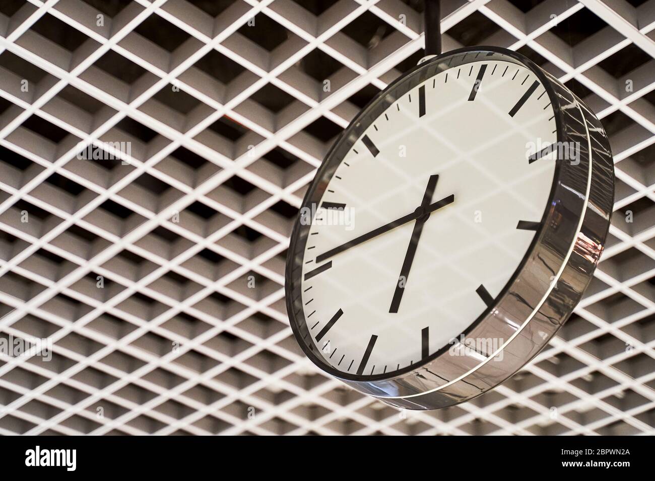 Modern clock with dial on structured wall background in black and white with chrome Stock Photo