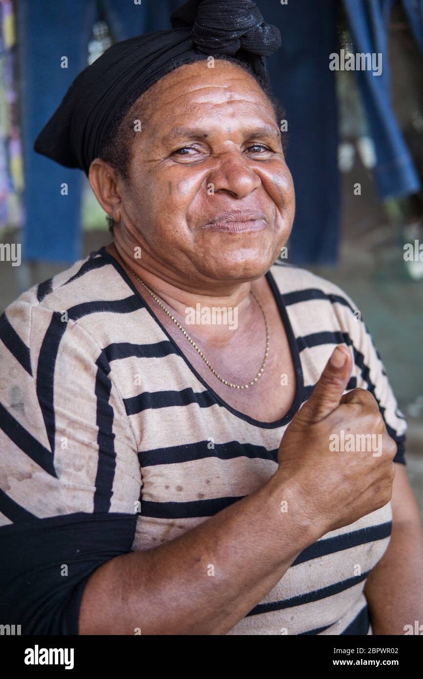 Port Moresby / Papua New Guinea: woman smiling at a street stall with grilled meats showing the thumb up Stock Photo