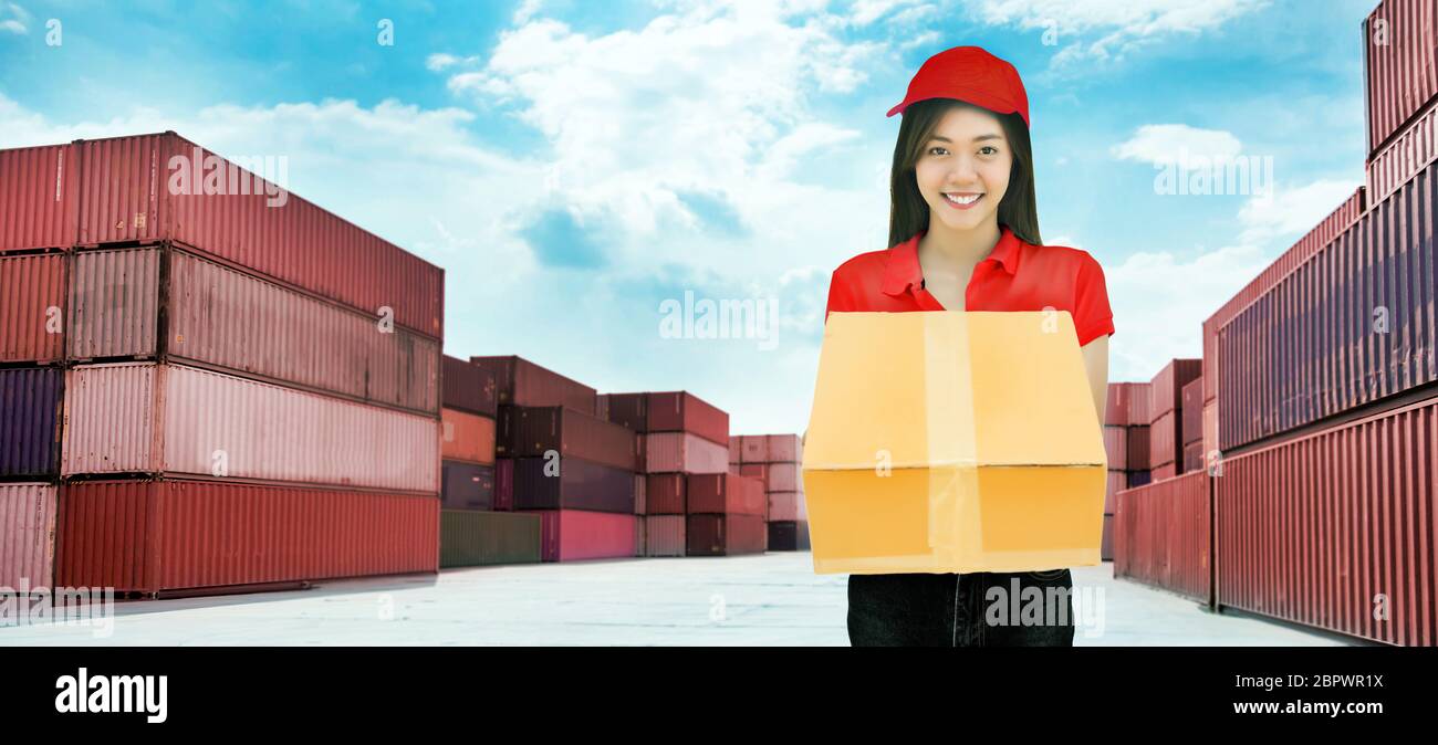 happy delivery service from logistic to customer from asian woman service on harbor background. Stock Photo