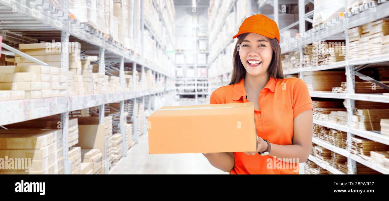 Asian woman show paper box inventory from warehouse with smile. good and easy shipping service concept Stock Photo